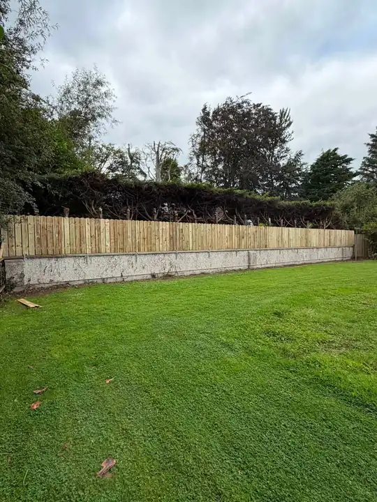 A new double fence along the top of a garden wall