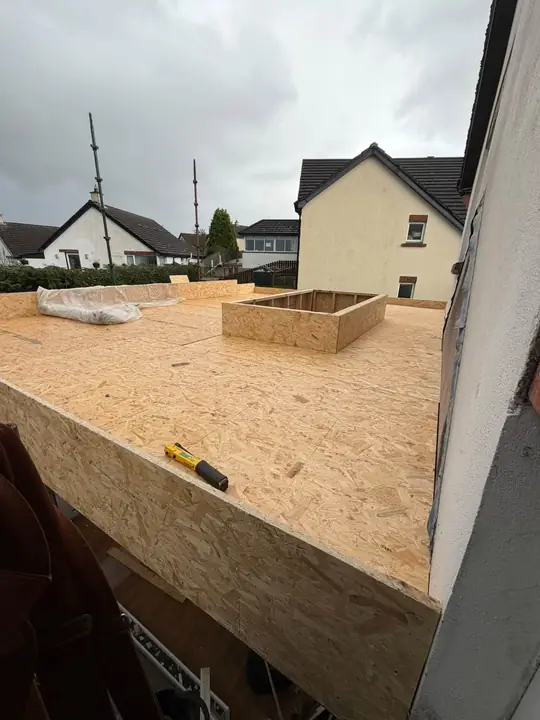 New timber decking boards on a flat roof, with houses behind