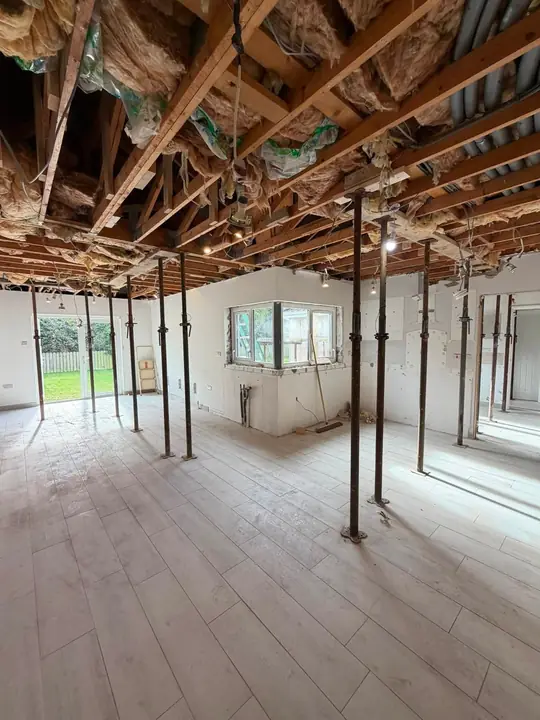 Inside a house being opened up, with the ceiling propped on steel props