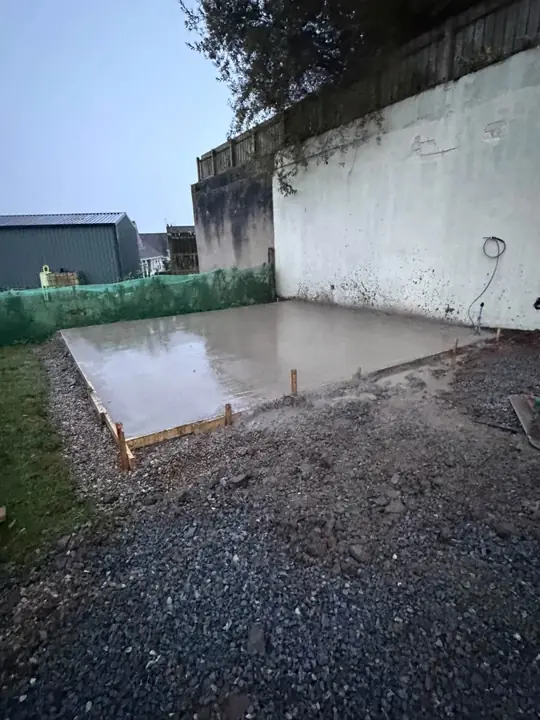 A newly concreted shed base inside timber shuttering